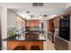 Well-lit kitchen with stainless steel appliances, wooden cabinets, tile floors and stylish green tile backsplash at 16814 N 31St Ave, Phoenix, AZ 85053