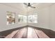 Sunlit bedroom with wood floors, a ceiling fan, and multiple windows showcasing outdoor scenery at 1825 W Ray Rd # 2111, Chandler, AZ 85224
