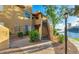 Condo building with exterior stairs, partial view of a lake, landscaping and covered porches at 1825 W Ray Rd # 2111, Chandler, AZ 85224