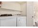Clean laundry room with full size washer and dryer and shelving at 1825 W Ray Rd # 2111, Chandler, AZ 85224