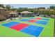 Outdoor pickleball courts with green, red, and blue surfaces, surrounded by lush landscaping and buildings at 1825 W Ray Rd # 2111, Chandler, AZ 85224