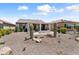 An outdoor patio boasts desert landscaping, cacti, and seating area with a fire pit at 21090 N 267Th Dr, Buckeye, AZ 85396