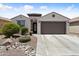 Charming single-story home with a two-car garage, desert landscaping, and a cozy front porch at 21090 N 267Th Dr, Buckeye, AZ 85396
