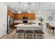 Stylish kitchen with wooden cabinetry, stainless steel appliances, a white countertop island, and pendant lighting at 21090 N 267Th Dr, Buckeye, AZ 85396