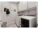 Well-organized laundry room with white cabinets and modern washer/dryer at 21090 N 267Th Dr, Buckeye, AZ 85396