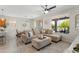 Bright living room with a sectional sofa, large windows, and an open layout connecting to the dining area at 21090 N 267Th Dr, Buckeye, AZ 85396