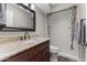 Bathroom with granite countertop, dark wood cabinets, mirror, and shower with curtain at 211 W Braeburn Dr, Phoenix, AZ 85023