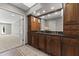 Primary bathroom boasts double sinks, dark wood cabinets, large mirror, and decorative sconces at 211 W Braeburn Dr, Phoenix, AZ 85023