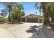 Charming home exterior featuring a spacious driveway, desert landscaping, and a flagstone facade at 211 W Braeburn Dr, Phoenix, AZ 85023