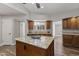 Charming kitchen featuring wood-look floors, wood cabinets, granite counters, and island with breakfast bar at 211 W Braeburn Dr, Phoenix, AZ 85023