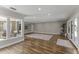 Spacious living room featuring wood-look floors, neutral paint, large windows, and access to the backyard at 211 W Braeburn Dr, Phoenix, AZ 85023