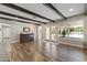 Living room with hardwood floors, beams, large windows, and a view of the pool at 211 W Braeburn Dr, Phoenix, AZ 85023