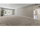 Large living room with neutral carpet, light walls, recessed lighting, and door to another room at 211 W Braeburn Dr, Phoenix, AZ 85023