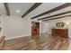 Living room with hardwood floors, beams, a wet bar, and furniture at 211 W Braeburn Dr, Phoenix, AZ 85023