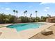 Backyard swimming pool with a rock feature, palm trees, and desert landscaping at 211 W Braeburn Dr, Phoenix, AZ 85023