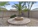 Private backyard features a cozy circular fire pit area with pavers and desert landscaping at 21337 E Waverly Dr, Queen Creek, AZ 85142