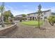 Spacious backyard features putting green, pool with waterfall, hot tub, and desert landscaping at 21337 E Waverly Dr, Queen Creek, AZ 85142