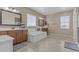 Bright bathroom featuring a standalone tub, dual sinks, and tile floors offering a spa like experience at 21337 E Waverly Dr, Queen Creek, AZ 85142