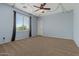 Bright bedroom with large window, neutral carpet, modern ceiling fan, and playful ivy decorations at 21337 E Waverly Dr, Queen Creek, AZ 85142