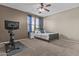 Bedroom features a bed, ceiling fan, closet, carpet, and space for gym equipment at 21337 E Waverly Dr, Queen Creek, AZ 85142