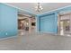 Empty living room features blue walls, neutral carpet, and access to other rooms at 21337 E Waverly Dr, Queen Creek, AZ 85142