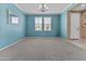 Unfurnished room features blue walls, neutral carpet, and natural light from the windows at 21337 E Waverly Dr, Queen Creek, AZ 85142