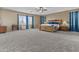 Relaxing bedroom featuring a large window, plush carpet, ceiling fan, and wood furniture at 21337 E Waverly Dr, Queen Creek, AZ 85142