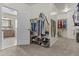 Spacious walk-in closet with custom shelving, hanging rods, and access to the primary bathroom featuring dual sinks at 21337 E Waverly Dr, Queen Creek, AZ 85142