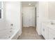 Bright bathroom with a soaking tub and shower, accented with white cabinets at 22502 W Tonopah Dr, Surprise, AZ 85387
