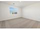 A cozy bedroom with neutral carpet and a window providing natural light at 22502 W Tonopah Dr, Surprise, AZ 85387