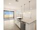 Modern kitchen island with granite countertops and pendant lighting, open to the dining and outdoor spaces at 22502 W Tonopah Dr, Surprise, AZ 85387