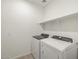 Laundry room with side by side washer and dryer with a shelf above at 22502 W Tonopah Dr, Surprise, AZ 85387