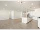 Open-concept living room with modern lighting, flows into the kitchen with an island at 22502 W Tonopah Dr, Surprise, AZ 85387