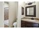 Bathroom featuring tiled backsplash, dark fixtures, framed mirror, vanity, and neutral color palette at 2300 E Sanoque Ct, Gilbert, AZ 85298