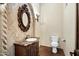 Elegant powder room with decorative mirror, marble countertop, and tiled accent wall at 2300 E Sanoque Ct, Gilbert, AZ 85298