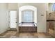 Luxurious bathroom featuring a soaking tub, walk-in shower, and travertine tile at 2300 E Sanoque Ct, Gilbert, AZ 85298