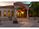 Elegant front entrance with stone archway, decorative iron doors, exterior lighting, and landscaped walkway at 2300 E Sanoque Ct, Gilbert, AZ 85298