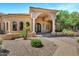 Elegant home exterior featuring a stone archway, stately columns, and a meticulously landscaped yard at 2300 E Sanoque Ct, Gilbert, AZ 85298