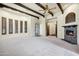 Spacious living room with wooden beam ceiling, stone fireplace, and neutral tones at 2300 E Sanoque Ct, Gilbert, AZ 85298