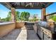 Covered outdoor kitchen featuring built-in stainless steel grill and ample counter space at 2300 E Sanoque Ct, Gilbert, AZ 85298