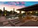 Beautiful pool area with covered patio, built-in grill, and meticulously landscaped surroundings at 2300 E Sanoque Ct, Gilbert, AZ 85298