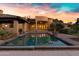 Beautiful backyard with a sparkling pool, tile roofed patio, and elegant home architecture at 2300 E Sanoque Ct, Gilbert, AZ 85298