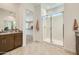 Bright bathroom featuring a glass shower, granite countertops, and neutral tile flooring at 23038 E Nightingale Rd, Queen Creek, AZ 85142