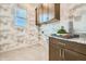Modern laundry room featuring stylish wallpaper, ample storage, and granite countertops at 23038 E Nightingale Rd, Queen Creek, AZ 85142