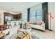 Bright, open-concept living room with modern furniture and view of the kitchen at 23038 E Nightingale Rd, Queen Creek, AZ 85142