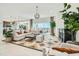 Bright living room featuring a large sectional, modern lighting, and backyard views at 23038 E Nightingale Rd, Queen Creek, AZ 85142