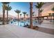 Resort-style pool featuring palm trees, ample lounge chairs, and a community clubhouse at 23038 E Nightingale Rd, Queen Creek, AZ 85142