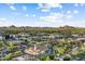 Expansive aerial view showcasing a serene suburban area with lush greenery and mountain views under a bright, partly cloudy sky at 2323 N Central Ave # Ph D, Phoenix, AZ 85004