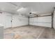 Spacious garage with concrete floors, white walls, and a large door with multiple windows at 2327 E Pebble Beach Dr, Tempe, AZ 85282