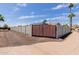 Gated entrance with block wall and palm trees against a vibrant blue sky with scattered clouds at 2327 E Pebble Beach Dr, Tempe, AZ 85282